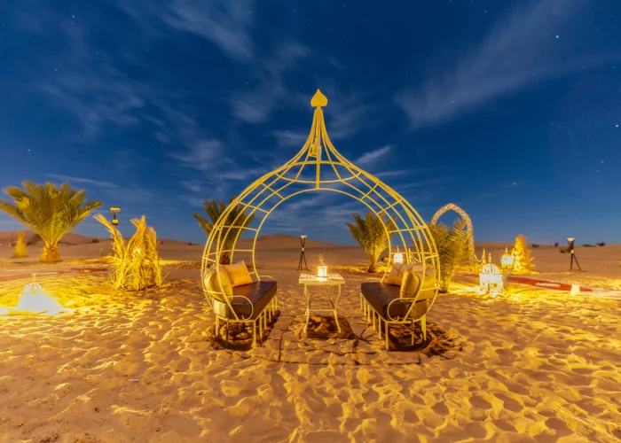 A desert camp lounge lit up at night near Merzouga